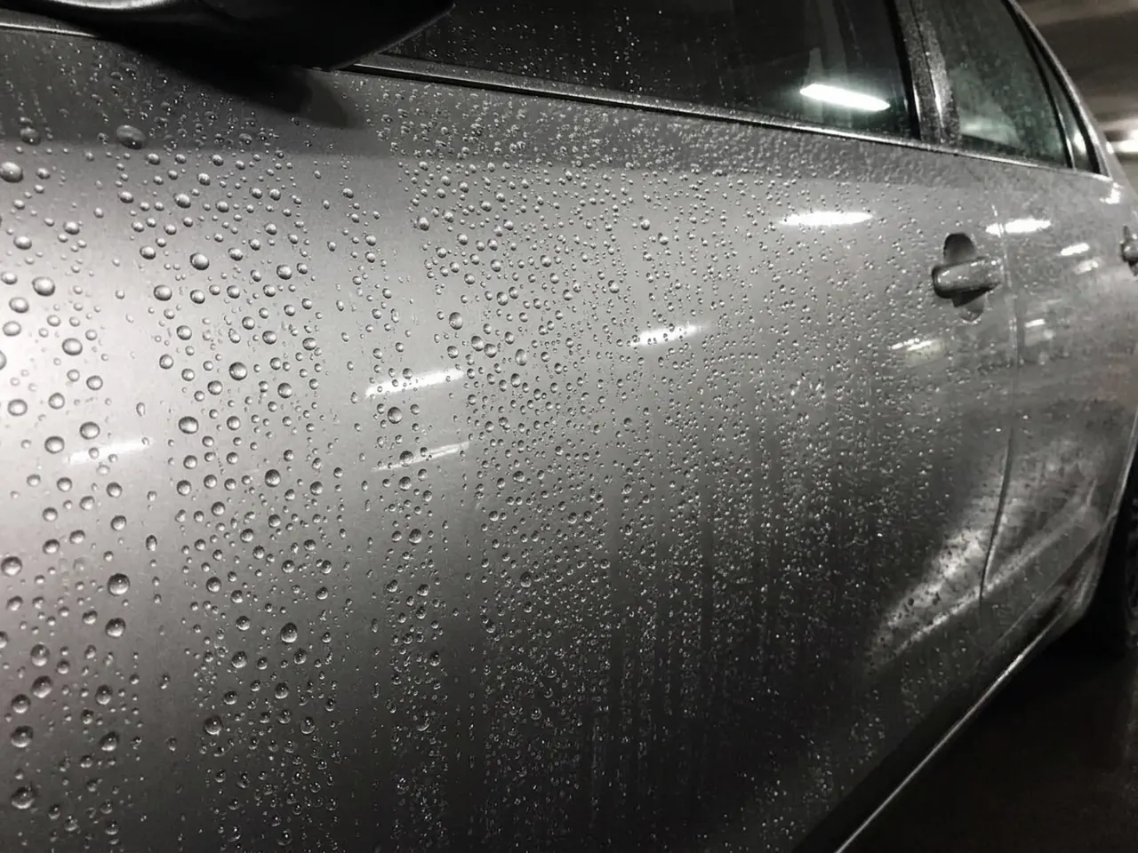 Same door after ceramic coating: water forms tight beads on the paint