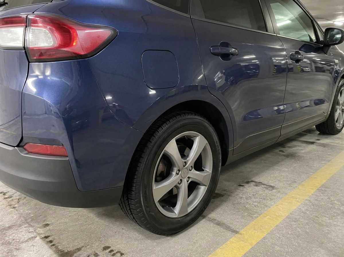 Same rear quarter panel after a hand wash: clean paint and decontaminated wheel