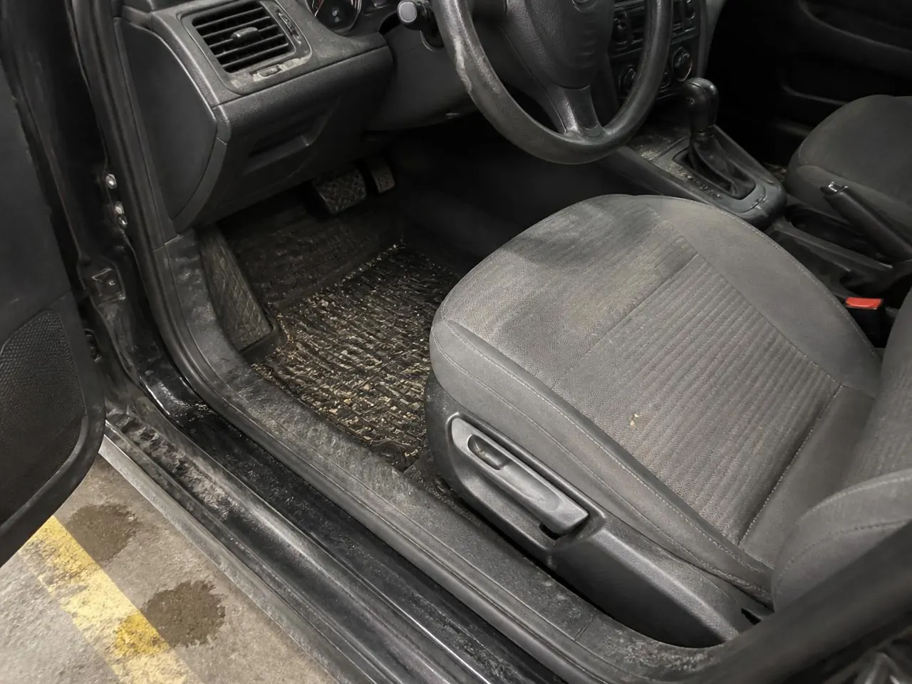 Cabin before cleaning: dust on the dashboard, crumbs on the seat and a dirty floor mat