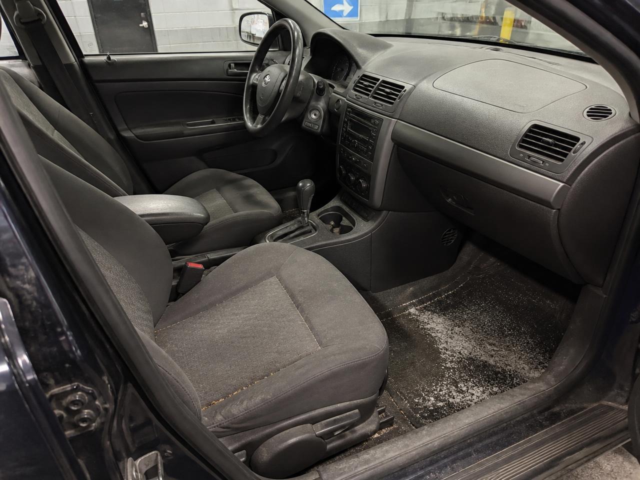 Cabin before cleaning: white salt stains on the carpet and dust on the dashboard